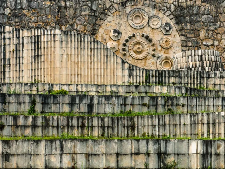 Circular stone ornaments above a weathered ribbed wall